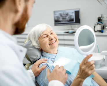 Elderly woman enjoying her smile in the dental office